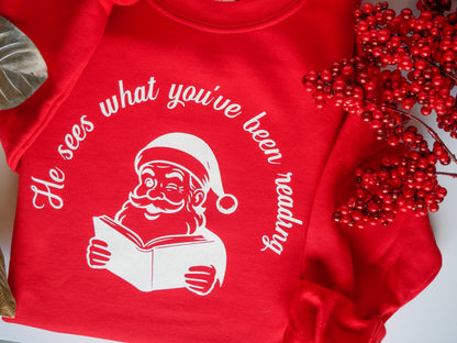 He Sees What You’ve Been Reading - Santa Reading Graphic, Red Funny Christmas Sweatshirt