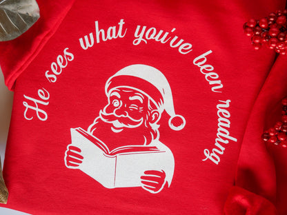 He Sees What You’ve Been Reading - Santa Reading Graphic, Red Funny Christmas Sweatshirt